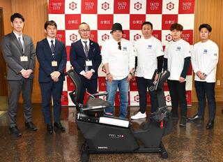 寄付者と区関係者の集合写真（寄贈品と共に）