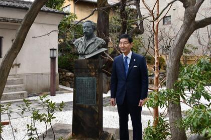 書道博物館創設者の中村不折像の前で撮影を行う区長の写真