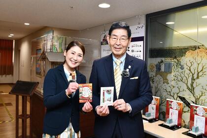 台東区民会館にて「大河ドラマ館来館記念証」を持つ区長